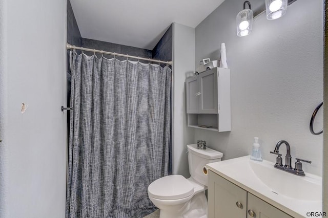 bathroom featuring a shower with curtain, vanity, and toilet