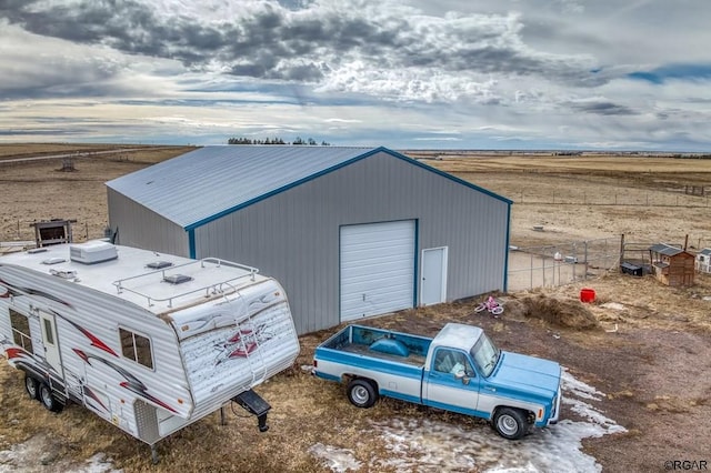 view of outbuilding with a rural view and a garage