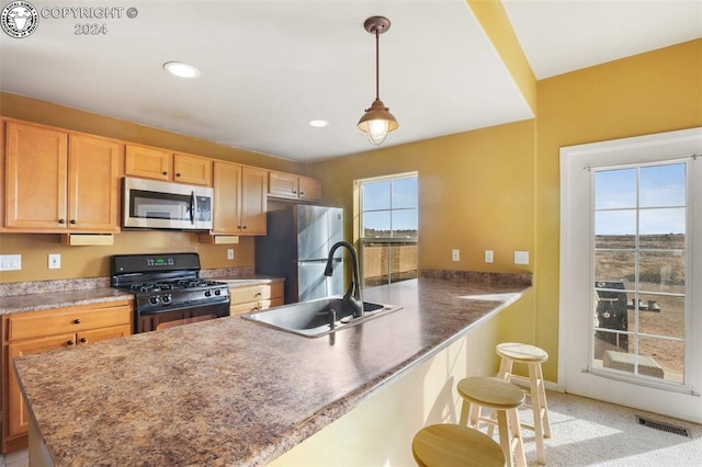 kitchen with pendant lighting, sink, a breakfast bar area, kitchen peninsula, and stainless steel appliances