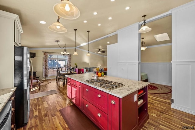 kitchen with ornamental molding, appliances with stainless steel finishes, and hanging light fixtures