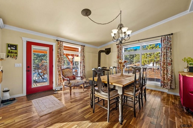 dining room featuring crown molding, plenty of natural light, dark hardwood / wood-style floors, and a chandelier