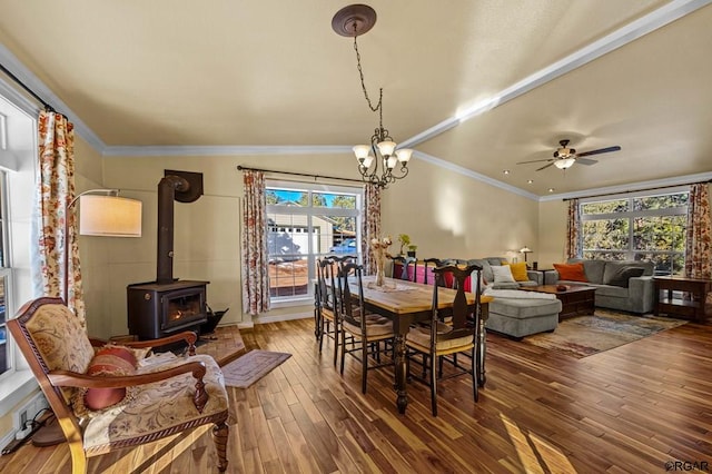 dining room with plenty of natural light, hardwood / wood-style floors, and a wood stove