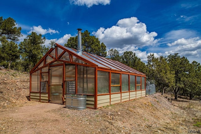 view of home's exterior with central AC unit and an outbuilding