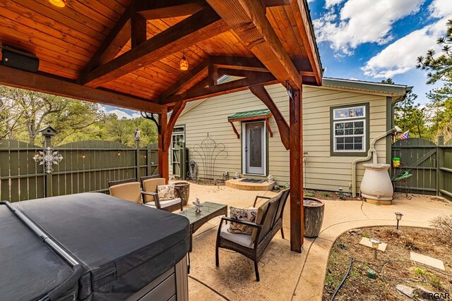 view of patio / terrace featuring a hot tub and a gazebo