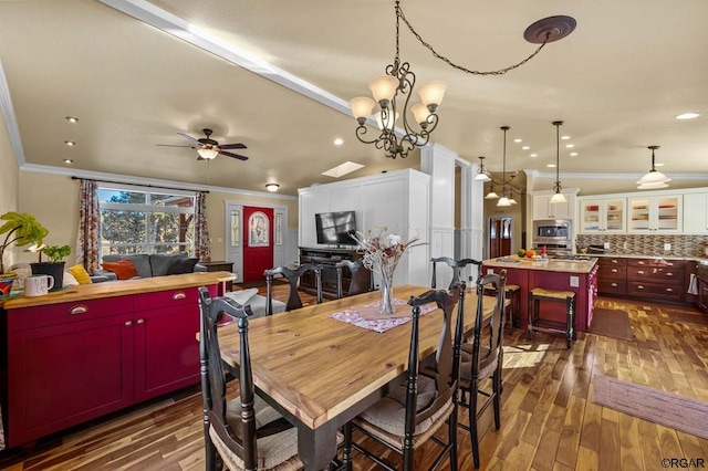 dining area featuring dark hardwood / wood-style flooring, crown molding, and ceiling fan with notable chandelier