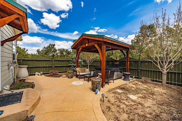 view of patio / terrace with a gazebo, a hot tub, and an outdoor fire pit