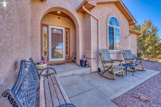 doorway to property featuring stucco siding