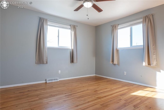 spare room featuring a wealth of natural light, ceiling fan, and light wood-type flooring