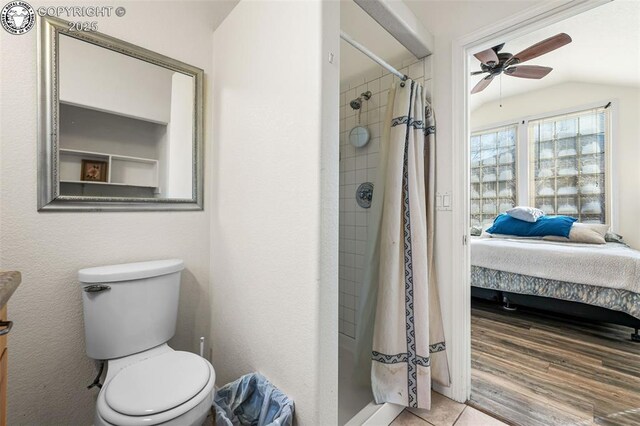 bathroom with lofted ceiling, ceiling fan, hardwood / wood-style floors, curtained shower, and toilet