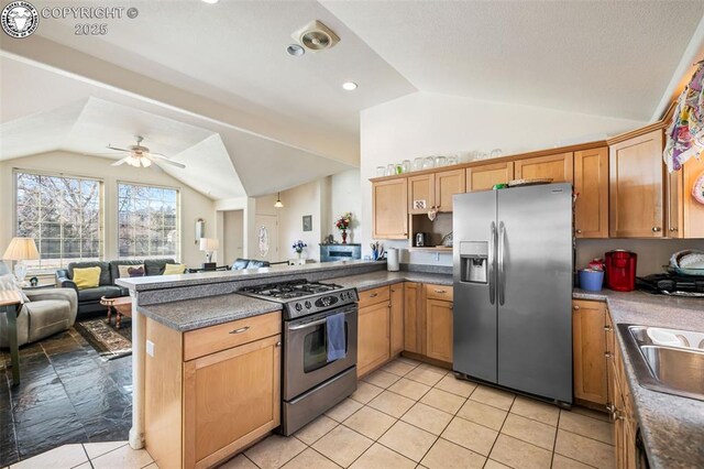 kitchen with lofted ceiling, light tile patterned floors, ceiling fan, appliances with stainless steel finishes, and kitchen peninsula