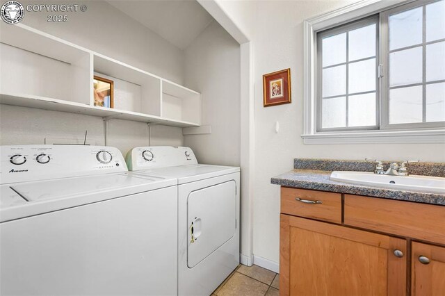 clothes washing area featuring sink, light tile patterned floors, and washer and dryer