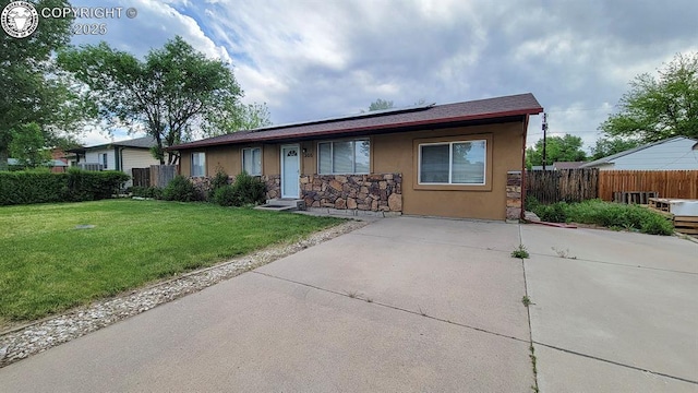 305 Meadowlark Cir, Florence, CO 81226 - view of front facade featuring roof mounted solar panels, stucco siding, and stone siding
