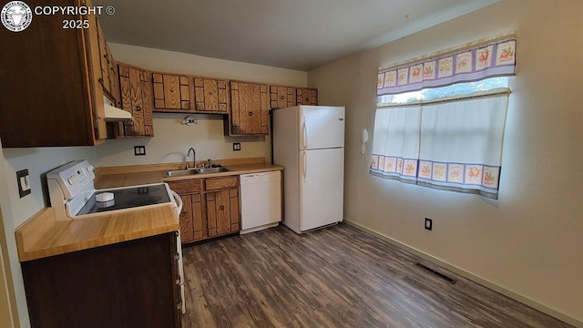 305 Meadowlark Cir, Florence, CO 81226 - kitchen featuring white appliances, a sink, under cabinet range hood, dark wood-type flooring, and brown cabinetry