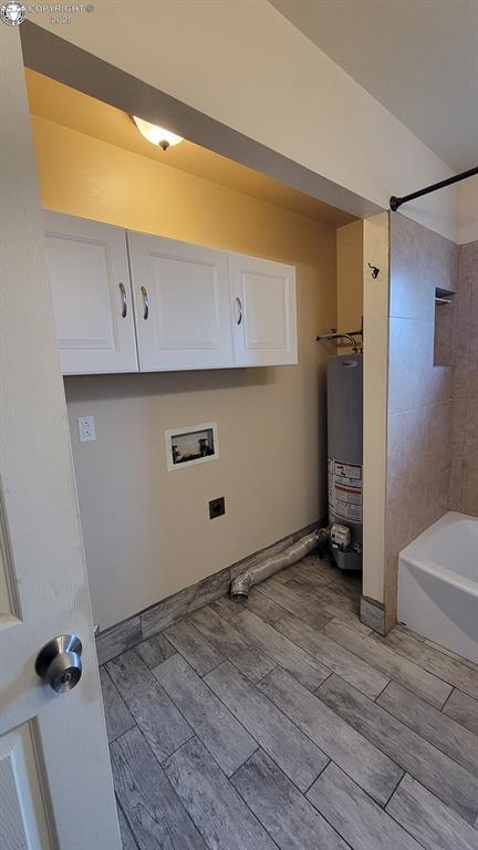 305 Meadowlark Cir, Florence, CO 81226 - laundry room with gas water heater, cabinet space, washer hookup, and wood tiled floors