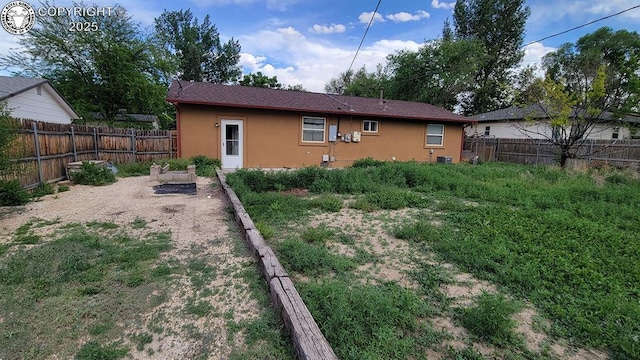 305 Meadowlark Cir, Florence, CO 81226 - back of house with stucco siding, a fenced backyard, and a vegetable garden