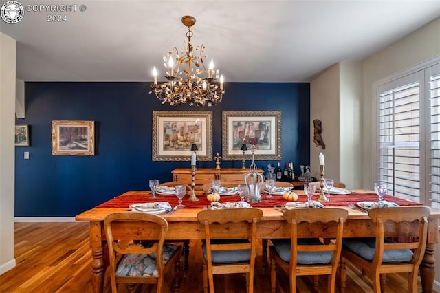 dining area with wood-type flooring and a chandelier