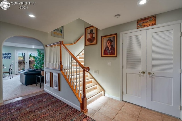 stairs featuring tile patterned flooring and french doors