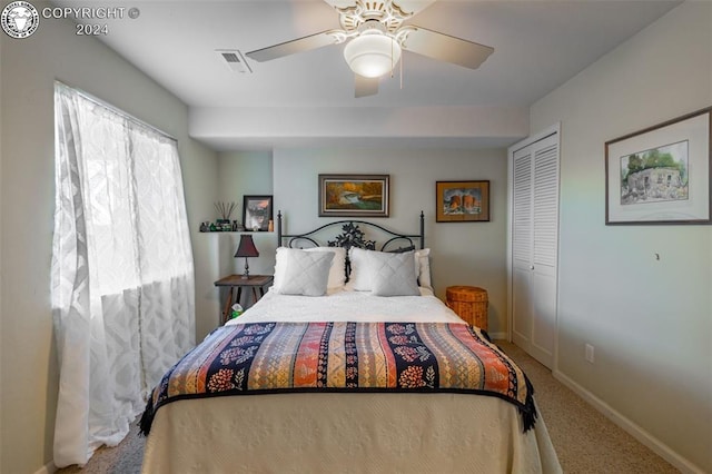 carpeted bedroom featuring ceiling fan and a closet