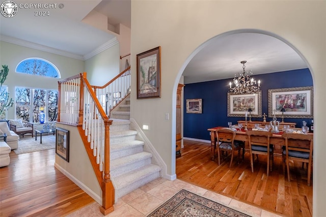 stairs featuring ornamental molding, tile patterned flooring, and a notable chandelier