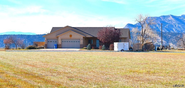 view of front of property featuring a garage, a mountain view, and a front yard