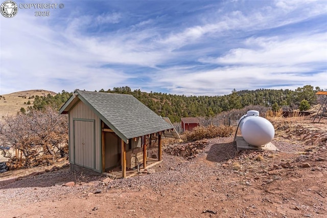 view of outbuilding featuring a mountain view and an outdoor structure