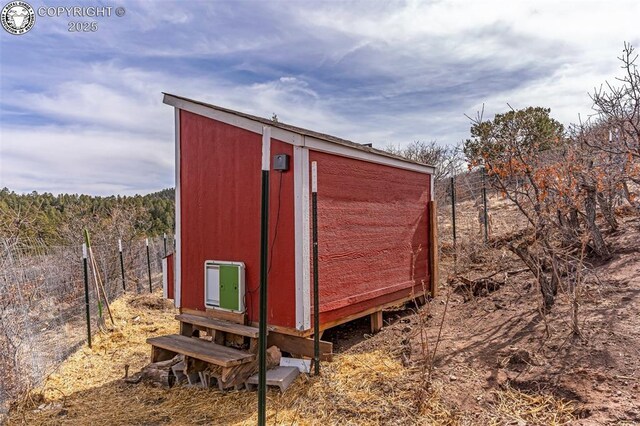 view of shed with entry steps and fence