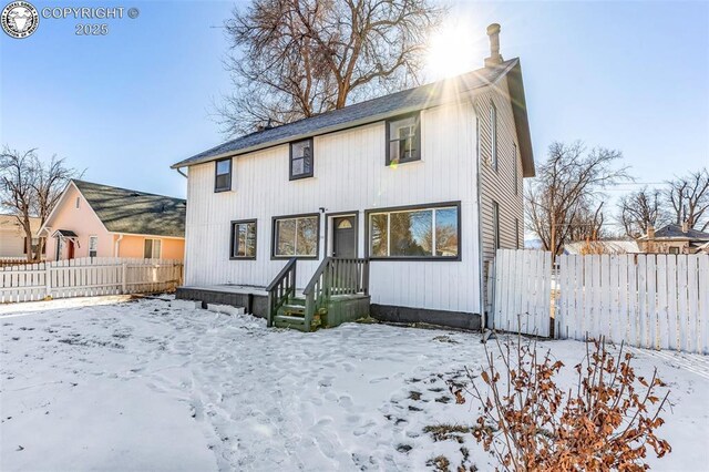 view of snow covered rear of property