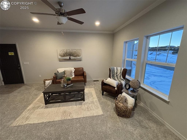 living room with ornamental molding, ceiling fan, and carpet flooring