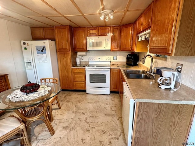 kitchen featuring tasteful backsplash, white appliances, sink, and a drop ceiling