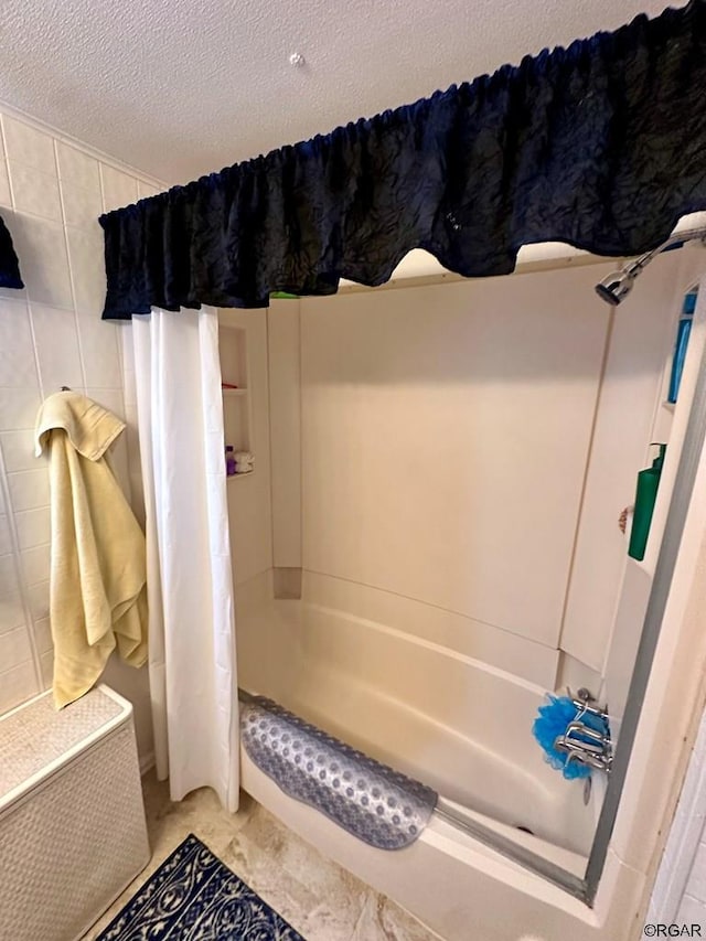 bathroom featuring shower / tub combo and a textured ceiling