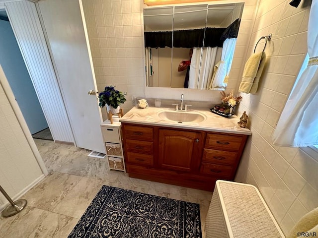 bathroom with tile walls and vanity