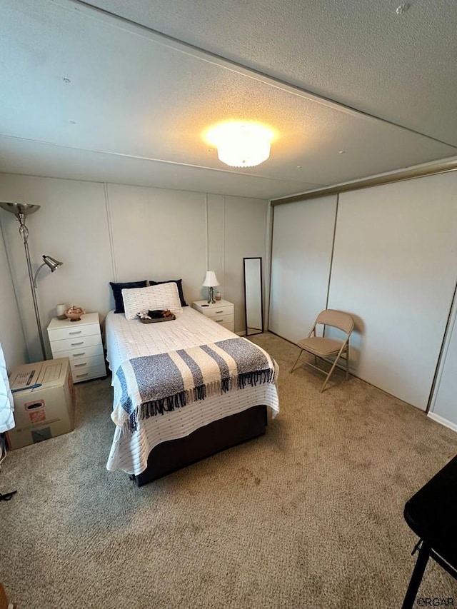 bedroom featuring carpet, a textured ceiling, and a closet