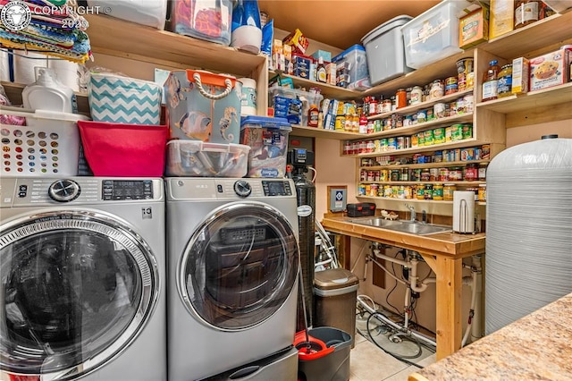 washroom featuring separate washer and dryer, sink, and light tile patterned flooring