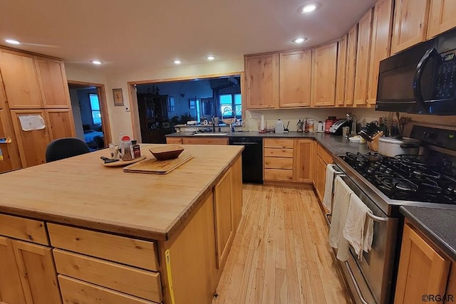 kitchen with sink, a center island, light hardwood / wood-style floors, black appliances, and light brown cabinets