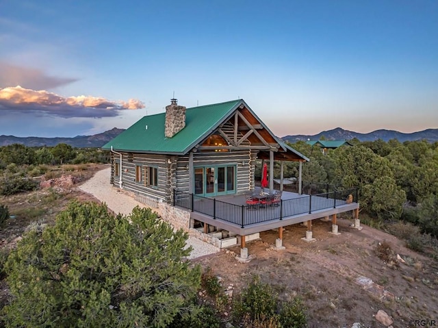 back house at dusk featuring a deck with mountain view