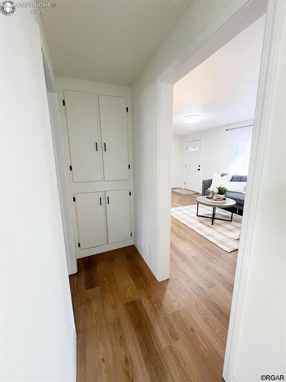 hallway featuring baseboards and wood finished floors