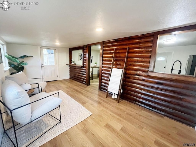 sitting room with recessed lighting, rustic walls, and light wood-style flooring