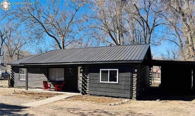 view of front of property featuring metal roof and log siding