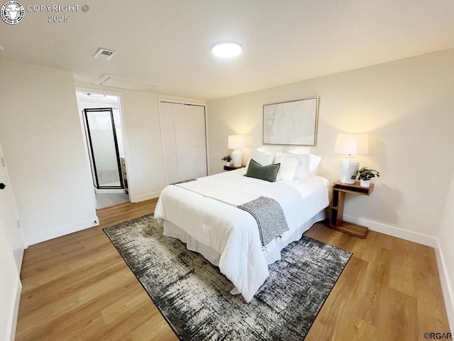 bedroom with baseboards, a closet, visible vents, and light wood-style floors