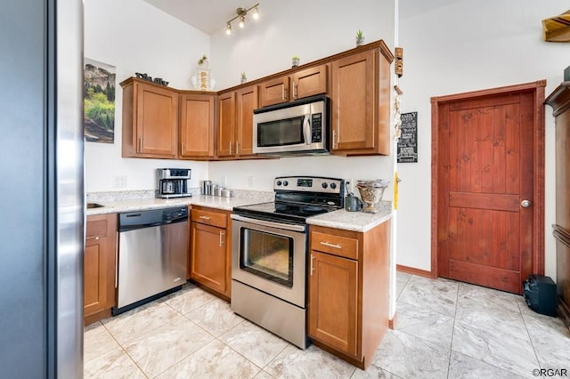 kitchen featuring stainless steel appliances and light stone countertops