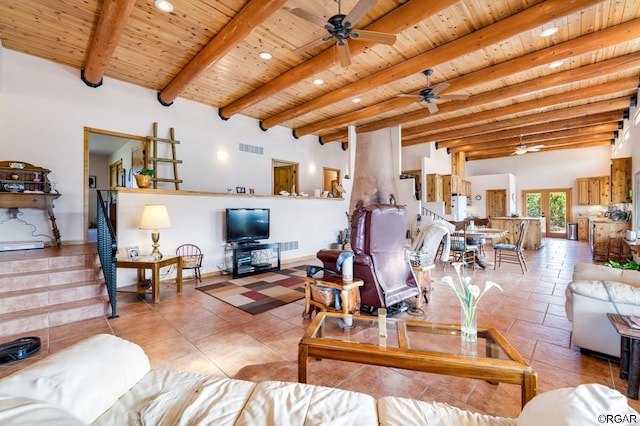 tiled living room featuring ceiling fan, wood ceiling, beamed ceiling, and a towering ceiling