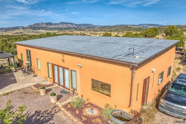 view of side of property with a patio, a mountain view, and a gazebo