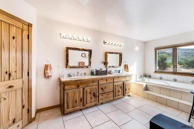 bathroom featuring tile patterned flooring, vanity, and a relaxing tiled tub