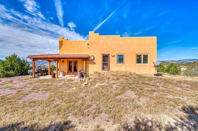 rear view of house featuring a yard and a patio