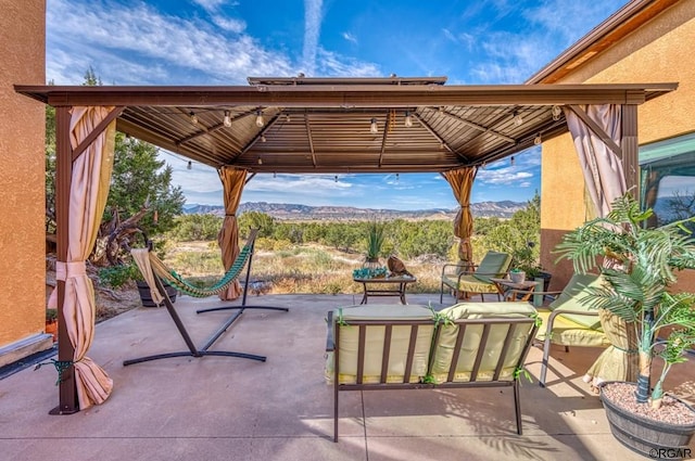 view of patio with an outdoor living space, a gazebo, and a mountain view