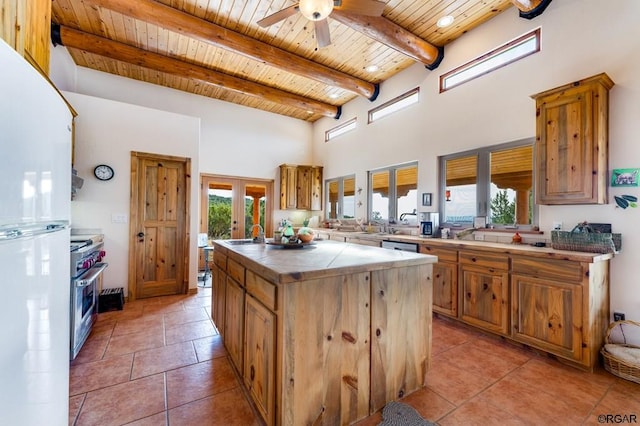 kitchen featuring a kitchen island, beamed ceiling, white refrigerator, wooden ceiling, and french doors