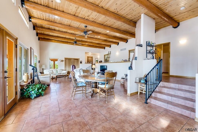 dining room featuring beam ceiling, a towering ceiling, and wood ceiling