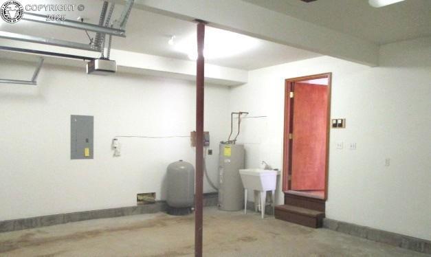 basement with water heater, sink, and electric panel