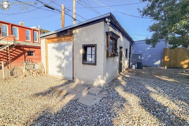 view of side of property with a garage and an outbuilding