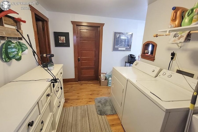 laundry area featuring cabinets, washer and dryer, and light hardwood / wood-style flooring